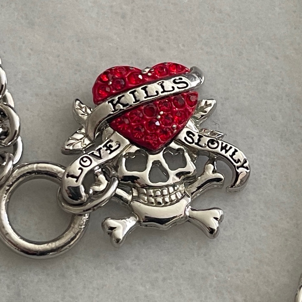 Silver tone chain bracelet with read heart charm.